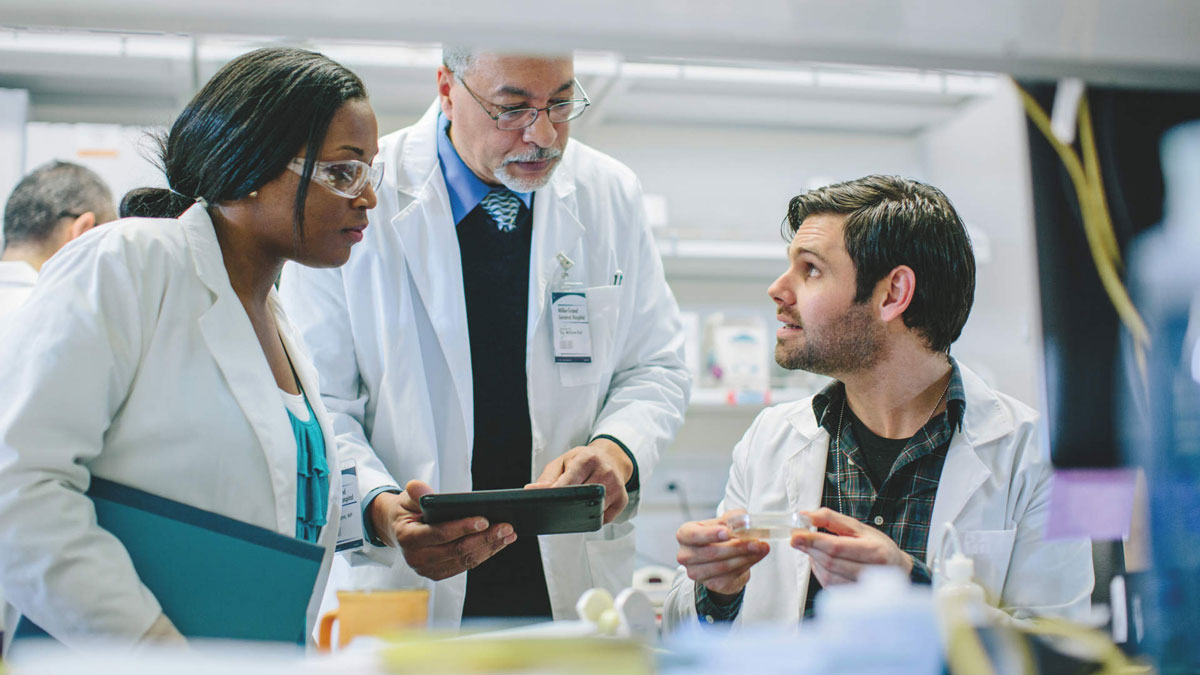 Male doctor discussing with coworkers in hospital